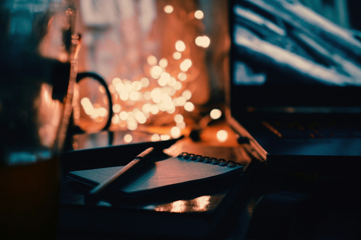 Notebook, pen, and laptop on a desk